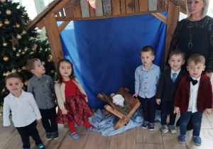 Grupa dzieci 3 - letnich na tle Szopki Bożonarodzeniowej.