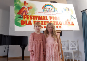Uczestniczki konkursu na tle napisu Festiwal Piosenki dla Przedszkolaka.