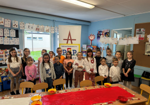 Uczestnicy akcji pozują przed wykonaną flagą Polski.