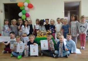 Grupa dzieci 5 -letnich trzymających dyplomy z okazji Dnia Chłopaka.