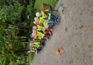 Grupa dzieci 3-letnich siedząca na ławeczce w parku