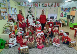 Grupa dzieci 3-4-letnich z wychowawcami i Mikołajem.